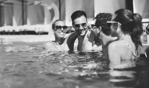 Adults lounging and laughing in outdoor pool at Jacquard Hotel Cherry Creek