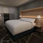 Jacuqard Hotel Cherry Creek Rendering of guest room with king bed, large wooden headboard and contemporary finishes,